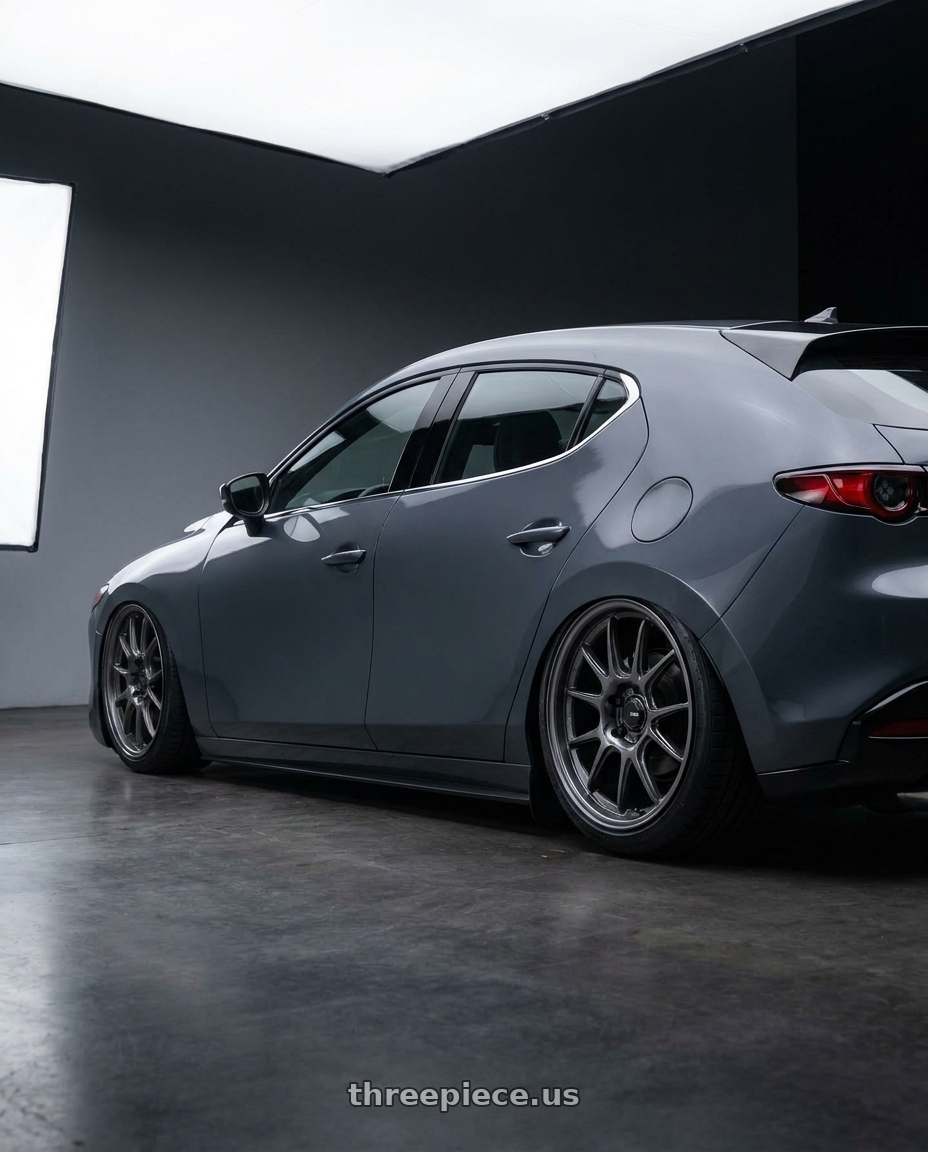2023 Mazda 3 hatchback premium with Konig Ampliform 5x114.3 18x9.5+25 Dark Metallic Graphite wheels rear three quarter view slight stretch tires