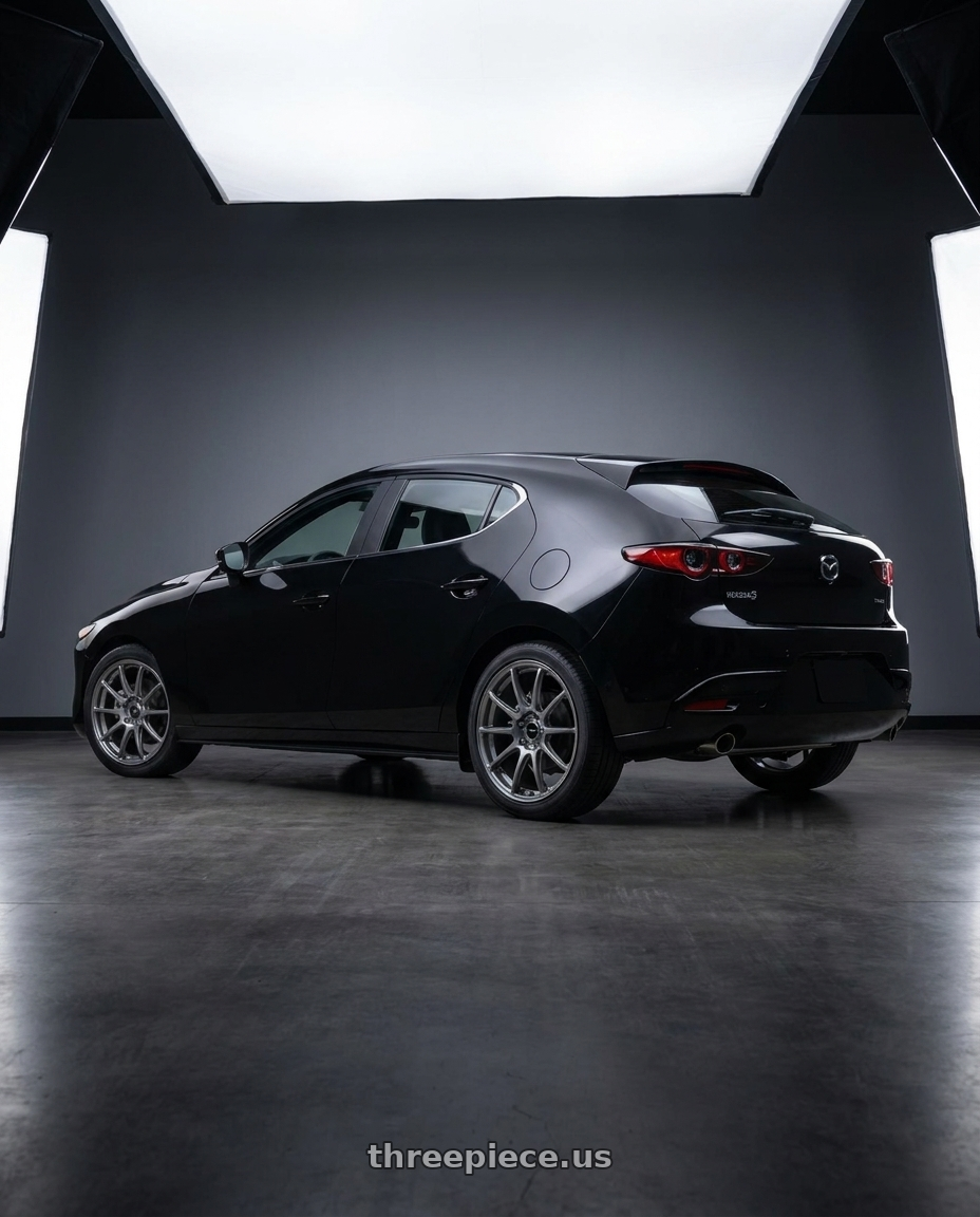 2026 mazda 3 hatchback in with Enkei Triumph 5x112 18x8+45 Storm Gray wheels rear three quarter view square tires
