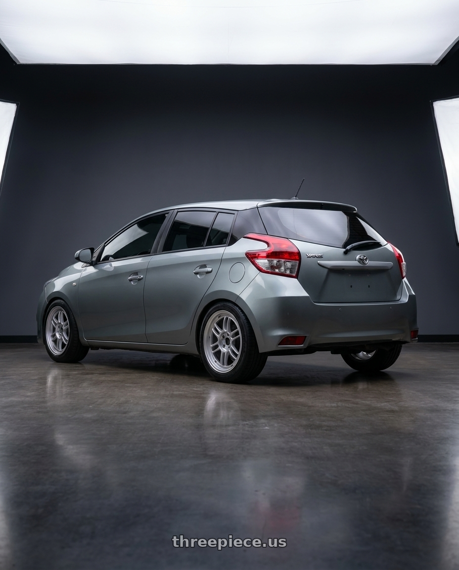 2015 Toyota Yaris with Enkei RPF1 4x100 15x8+28 Silver wheels rear three quarter view square tires
