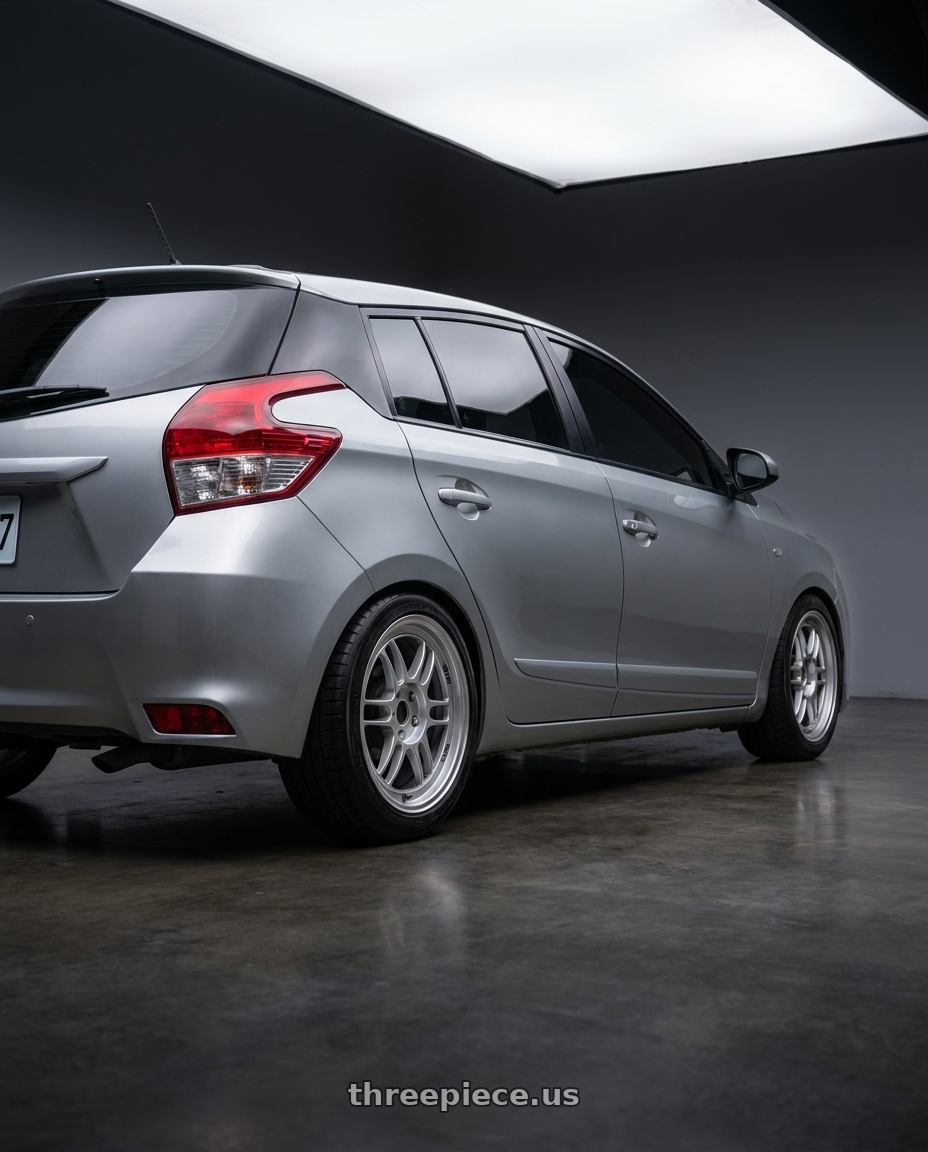 2015 Toyota Yaris with Enkei RPF1 4x100 16x8+38 Silver wheels rear three quarter view square tires