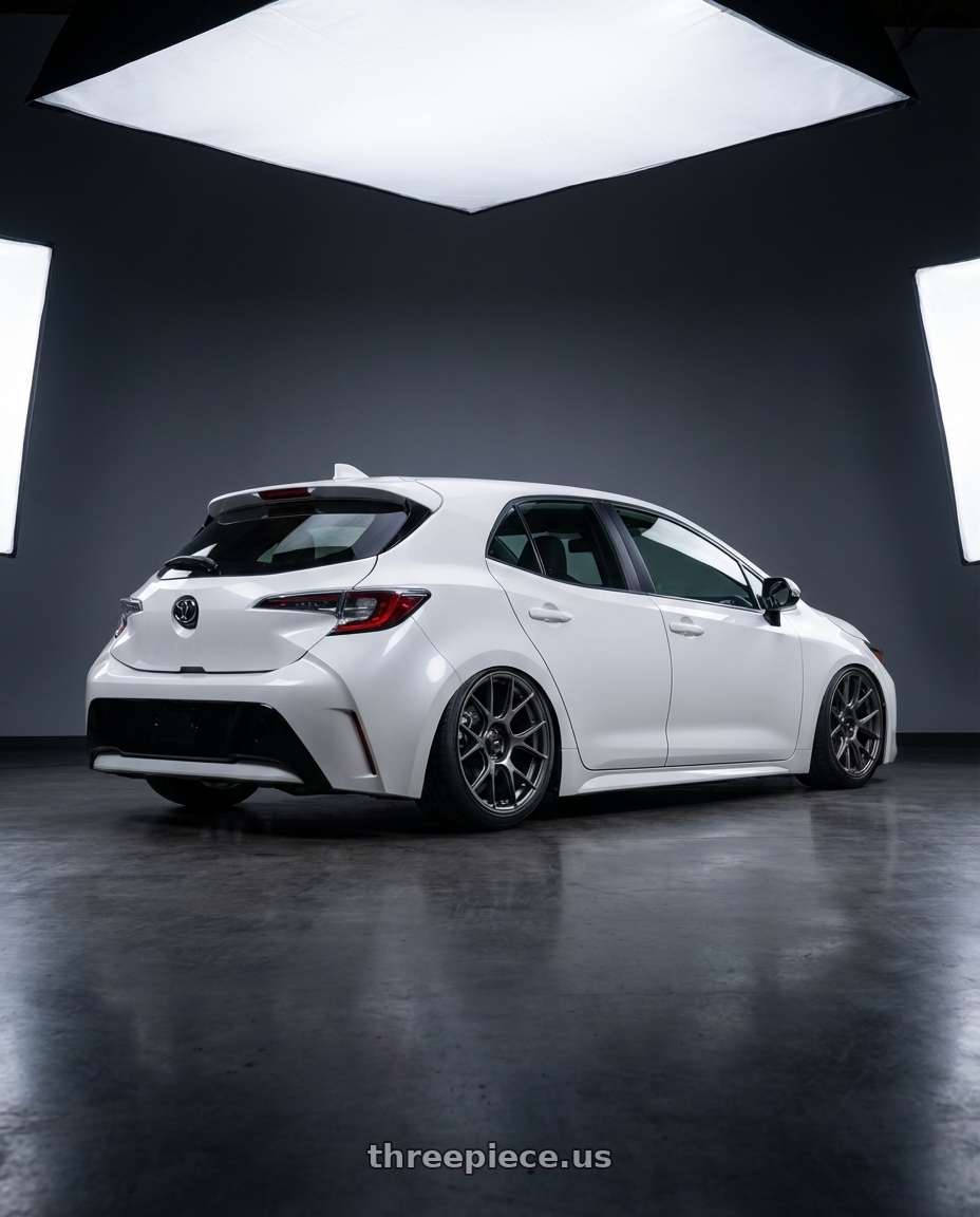 2023 Toyota Corolla Hatchback with Konig Ampliform 5x114.3 18x9.5+35 Dark Metallic Graphite wheels rear three quarter view slight stretch tires