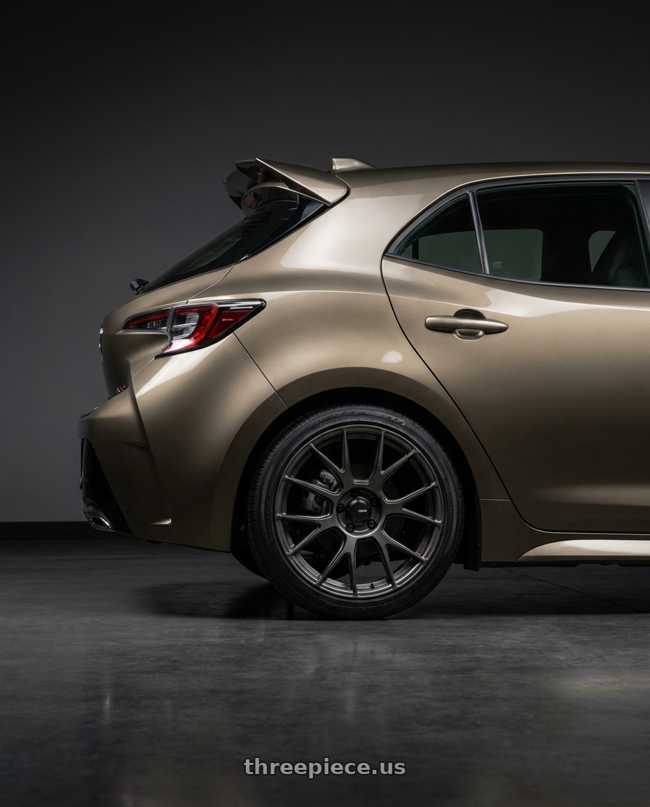 2019 Corolla Hatch Xse Oxidize Bronze With Spoiler with Konig Ampliform 5x100 18x8.5+44 Dark Metallic Graphite wheels rear three quarter view square tires