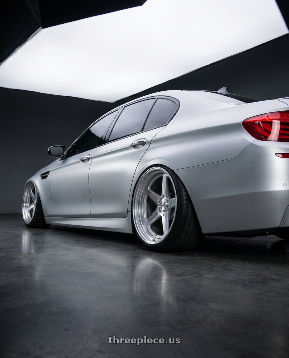 2014 BMW M5 with DOLCE PERFORMANCE STELLA 5x120 20x10 +40 Gloss Silver wheels rear three quarter view extreme stretch tires