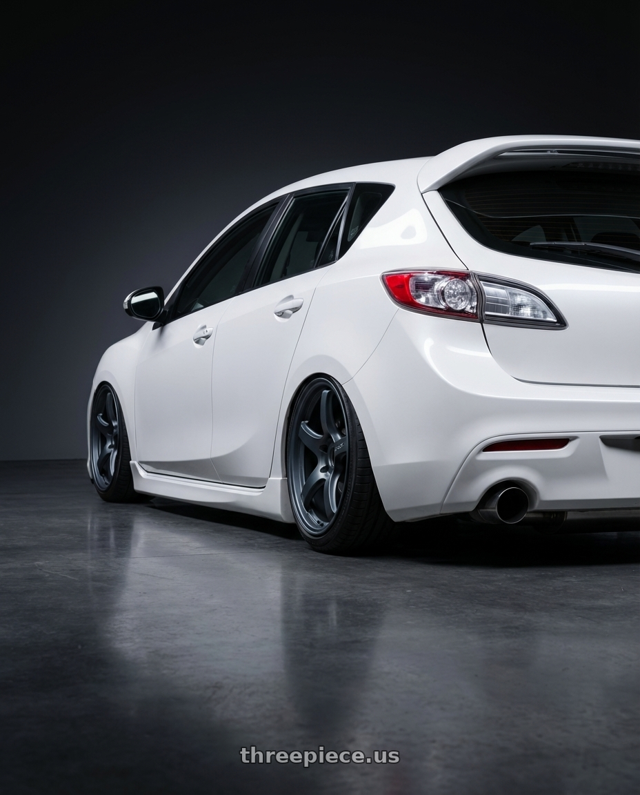 2012 Mazda Mazdaspeed3 with Gram Lights 57CR 5x114.3 18x9.5+38 Gunblue II wheels rear three quarter view slight stretch tires