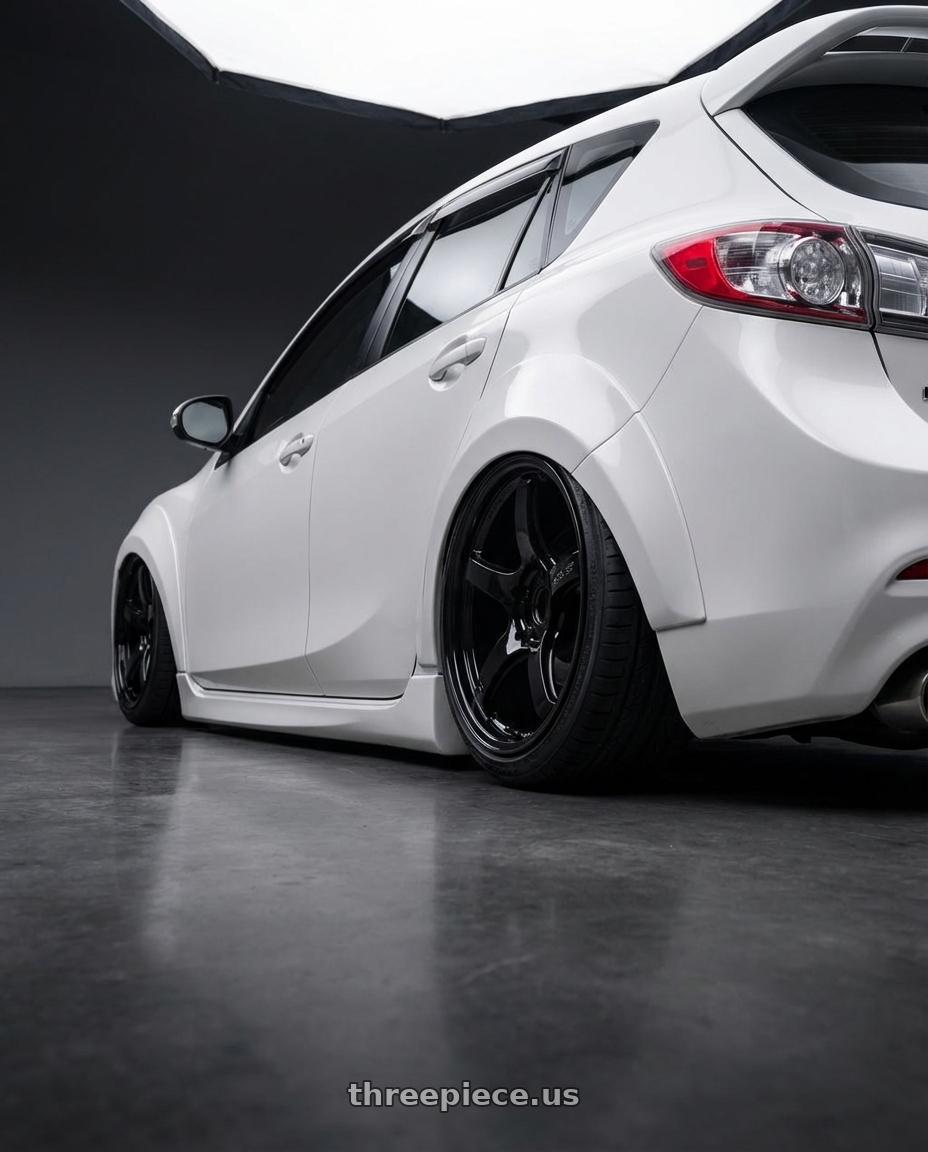 2012 Mazda Mazdaspeed3 with Gram Lights 57CR 5x114.3 18x9.5+22 Glossy Black wheels rear three quarter view slight stretch tires