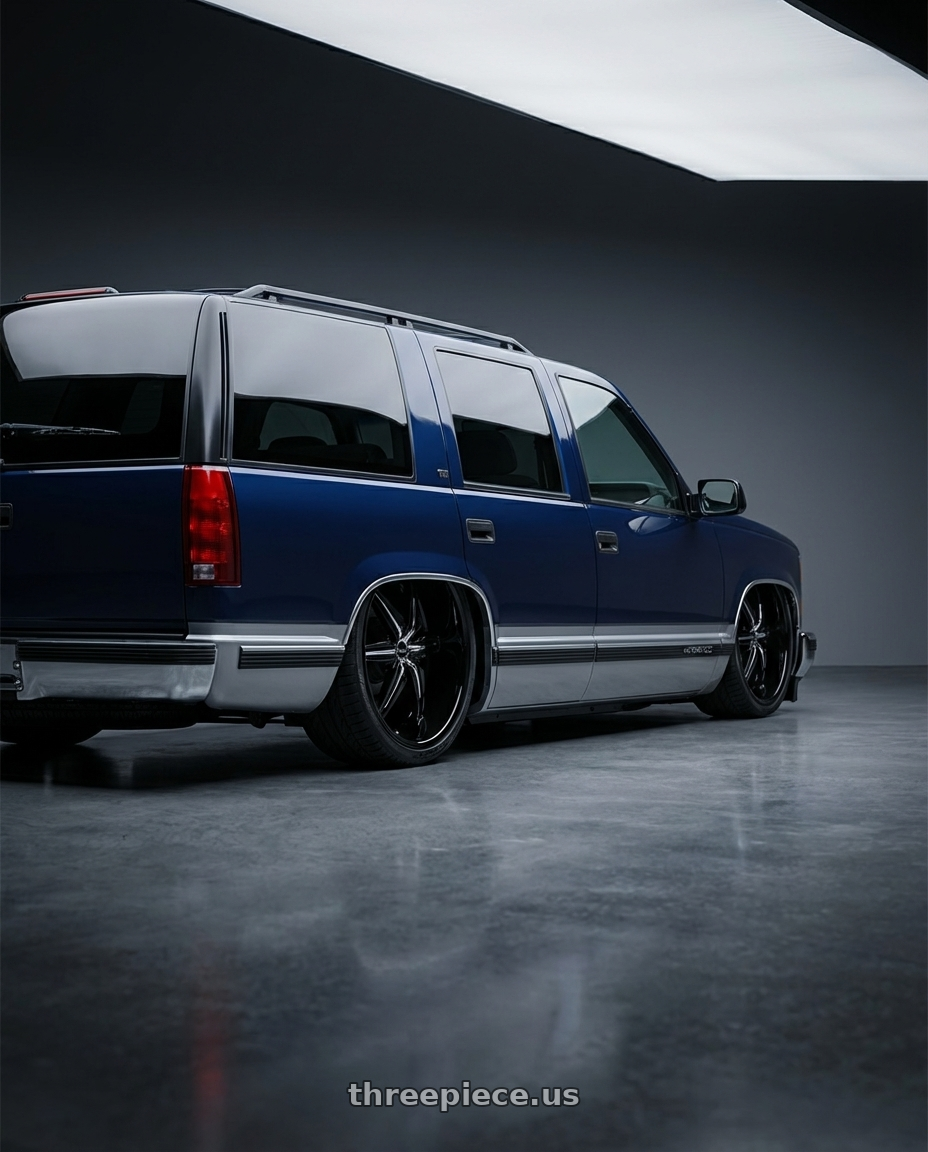 1999 Chevrolet Tahoe with Helo HE866 5X114.3/5X120.65 26X9.5 +10 GLOSS BLACK WITH REMOVABLE CHROME ACCENTS wheels rear three quarter view extreme stretch tires