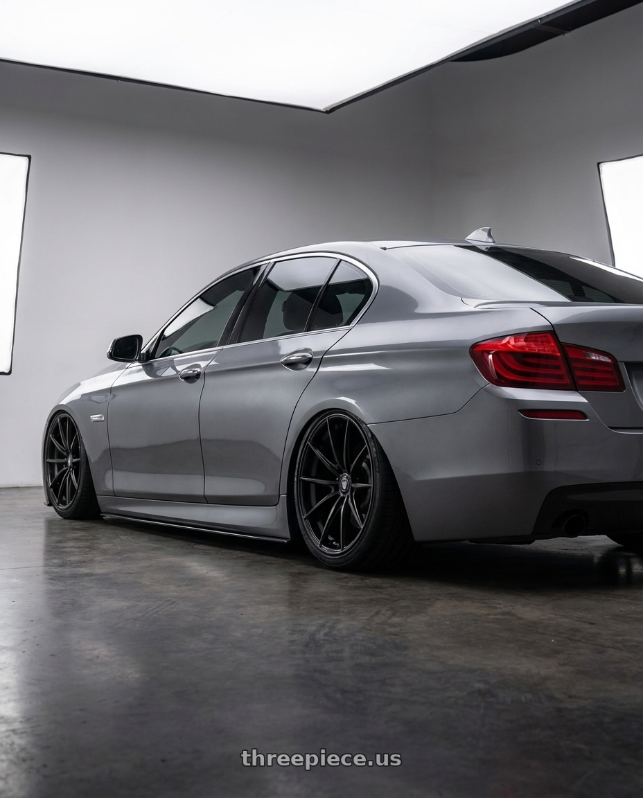 2016 BMW 5 Series F10 with Konig Oversteer 5x120 20x9.5+35 Gloss Black wheels rear three quarter view slight stretch tires