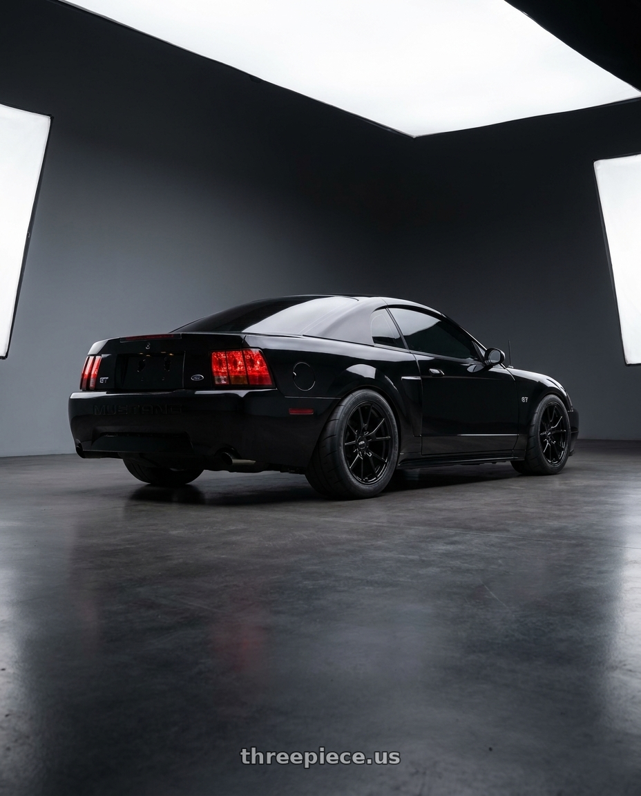 2004 Ford Mustang GT Black with O.E. Revolution TS-1 5x114.3 18x8.5 +35 Gloss Black wheels rear three quarter view meaty tires