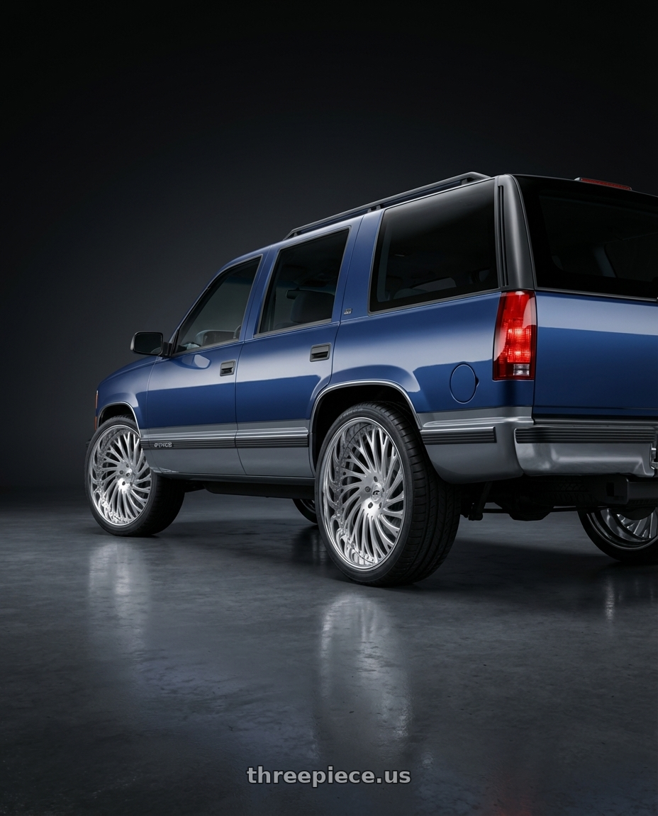 1999 Chevrolet Tahoe with Amani Vamos 5x112/5X114.3 22x9 +32 Brush Center Chrome Lip wheels rear three quarter view square tires