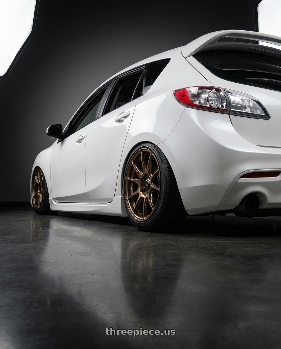 2012 Mazda Mazdaspeed3 with Konig Ampliform 5x114.3 18x9.5+25 Gloss Bronze wheels rear three quarter view slight stretch tires