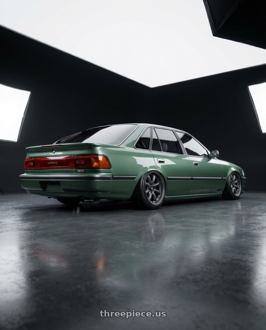 1991 Toyota Corona GLXi with Enkei Compe 4x100 16x7+38 gunmetal wheels rear three quarter view slight stretch tires