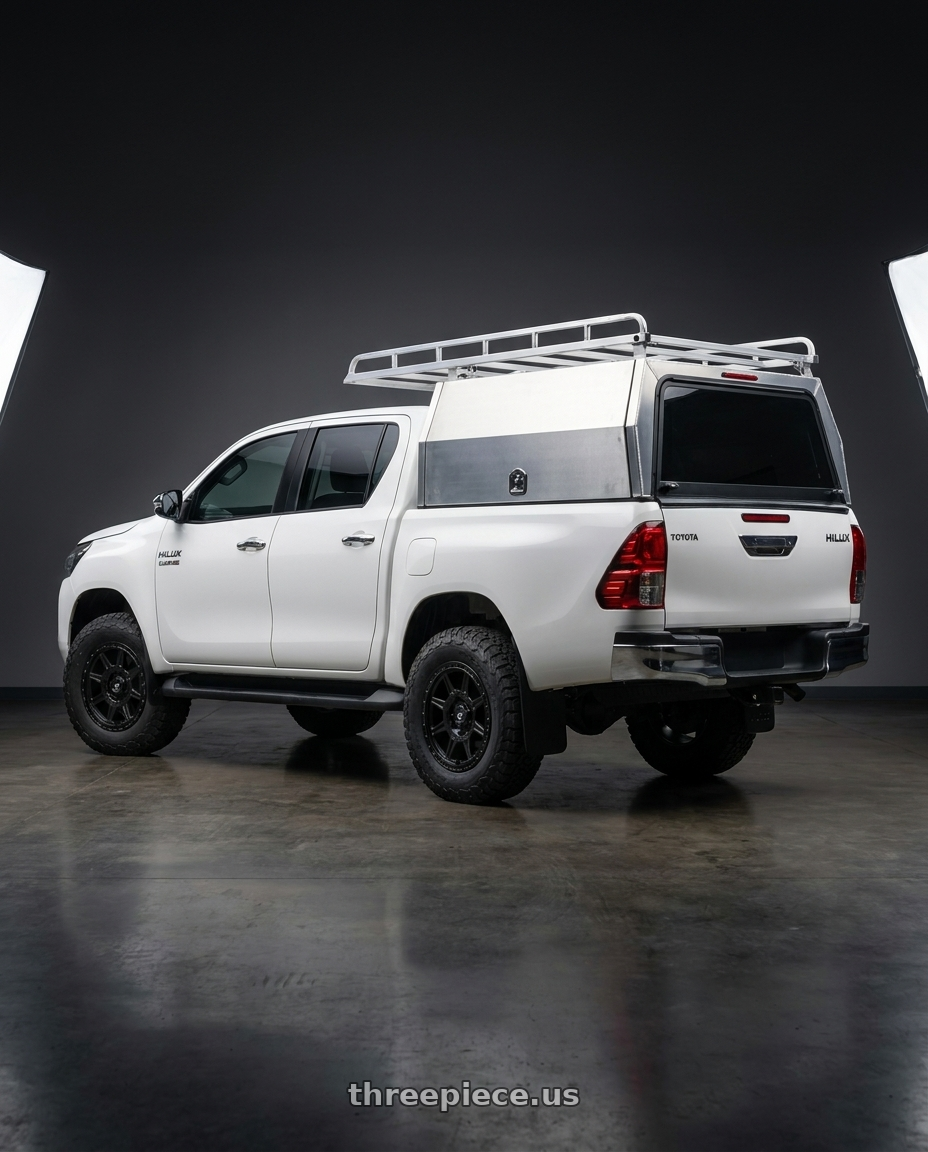 2025 Toyota hilux with Gear Off Road 758SB 5X110/5x127 17x8 +35 Satin Black wheels rear three quarter view meaty tires