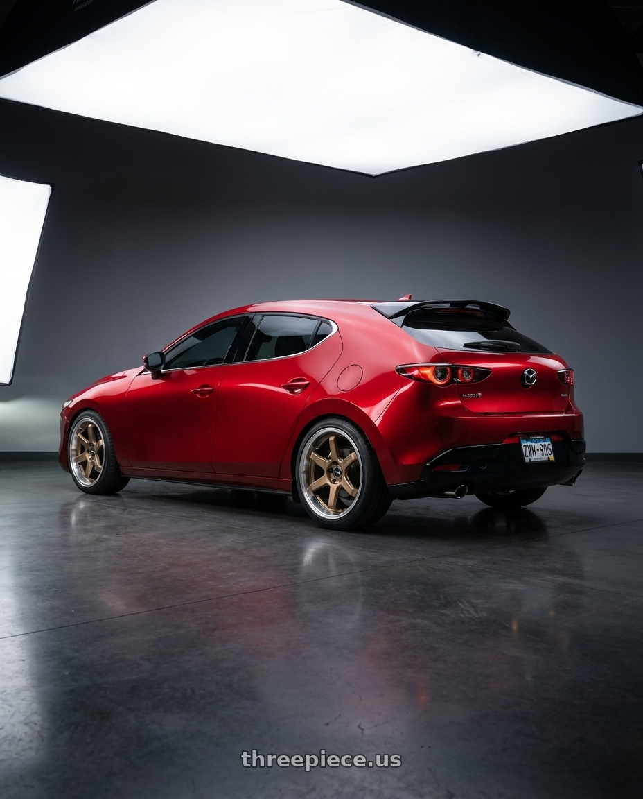 2026 Mazda 3 hatchback soul red with F1R FC7 5x114 18x8.5 +38 Satin Bronze/Polish Lip wheels rear three quarter view square tires