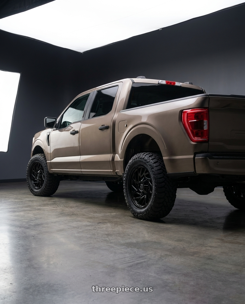2019 Ford F-150 with Gear Off Road 769B 6X135/6x139.7 20x9 +0 Gloss Black wheels rear three quarter view meaty tires
