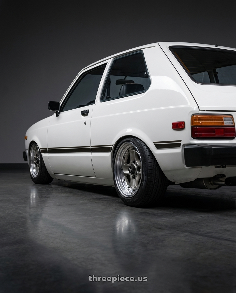 1981 toyota starlet  with Work Equip 40 4x114.3 15x6.5 +16 a disk Brut Silver wheels rear three quarter view square tires