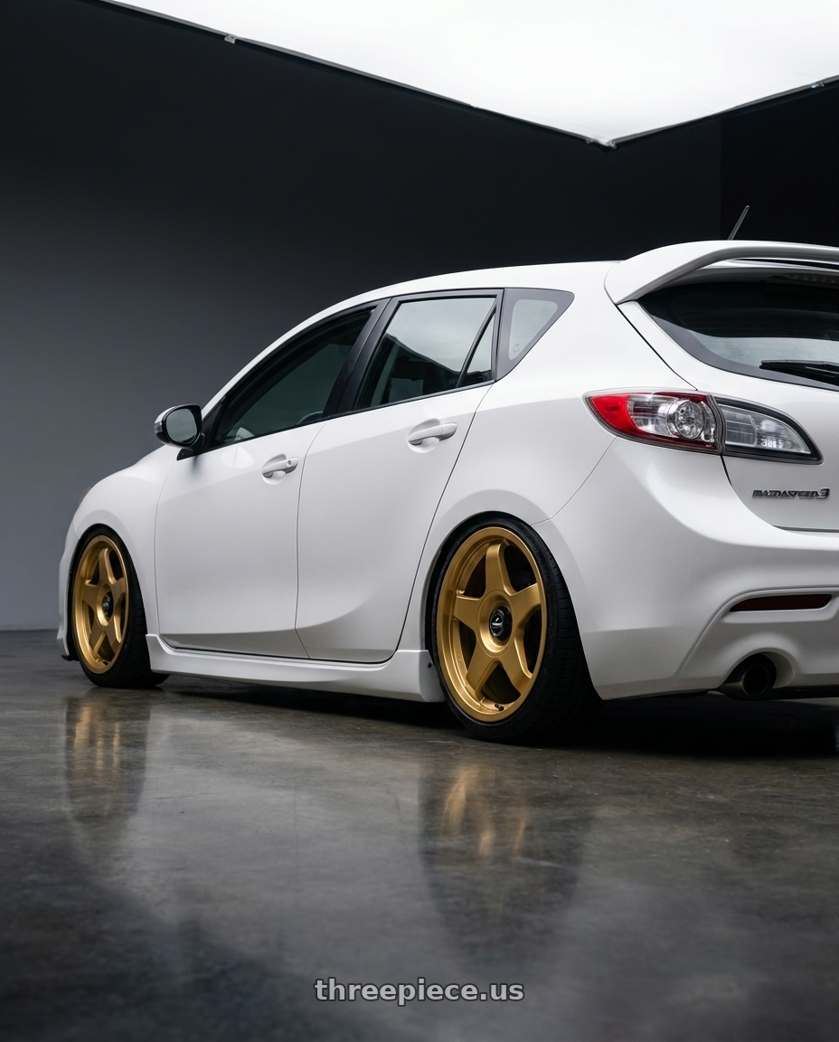2012 Mazda Mazdaspeed3 with fifteen52 CHICANE 5x114.3 / 5x100 18x8.5 +35 GOLD (GLOSS GOLD) wheels rear three quarter view slight stretch tires