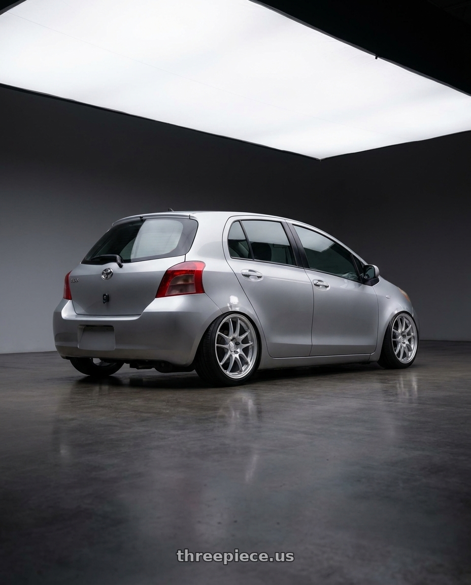 2006 Toyota Yaris with Enkei PF01 4x100 17x7+38 Silver wheels rear three quarter view slight stretch tires