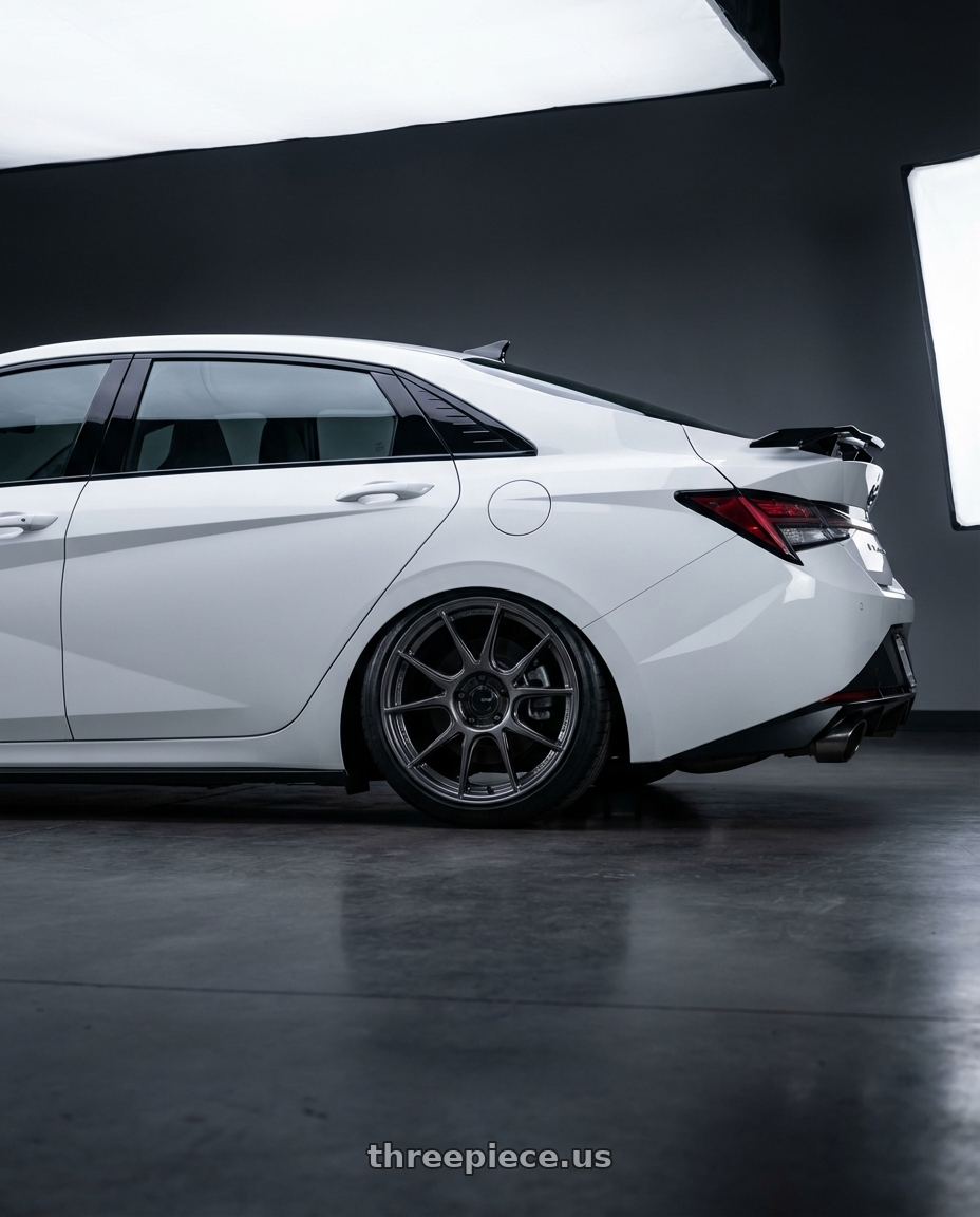 2024 Hyundai Elantra N with Konig Ampliform 5x114.3 19x9.5+25 Dark Metallic Graphite wheels rear three quarter view slight stretch tires