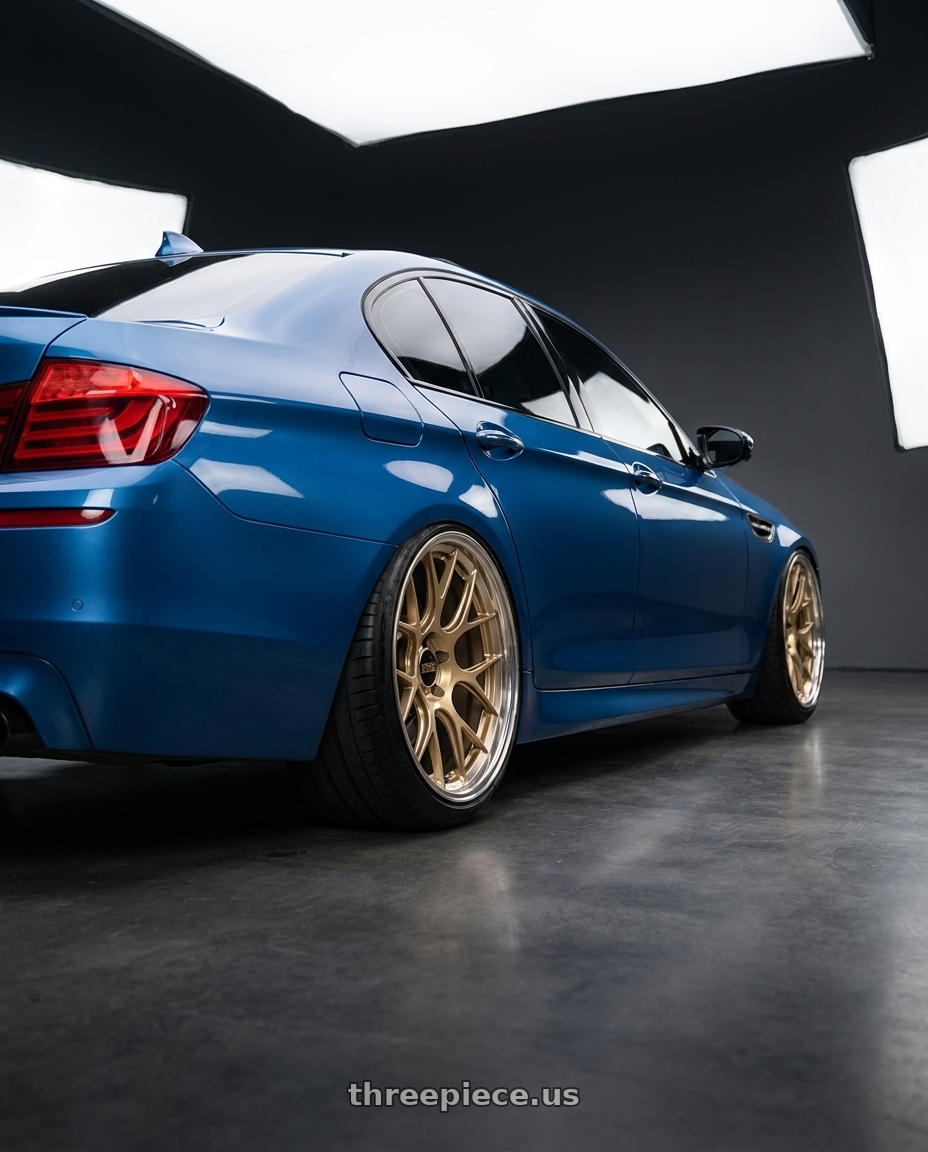 2012 BMW 550i with BBS RE-V7 5x112 21x10.5 +15 Gloss Gold wheels rear three quarter view extreme stretch tires