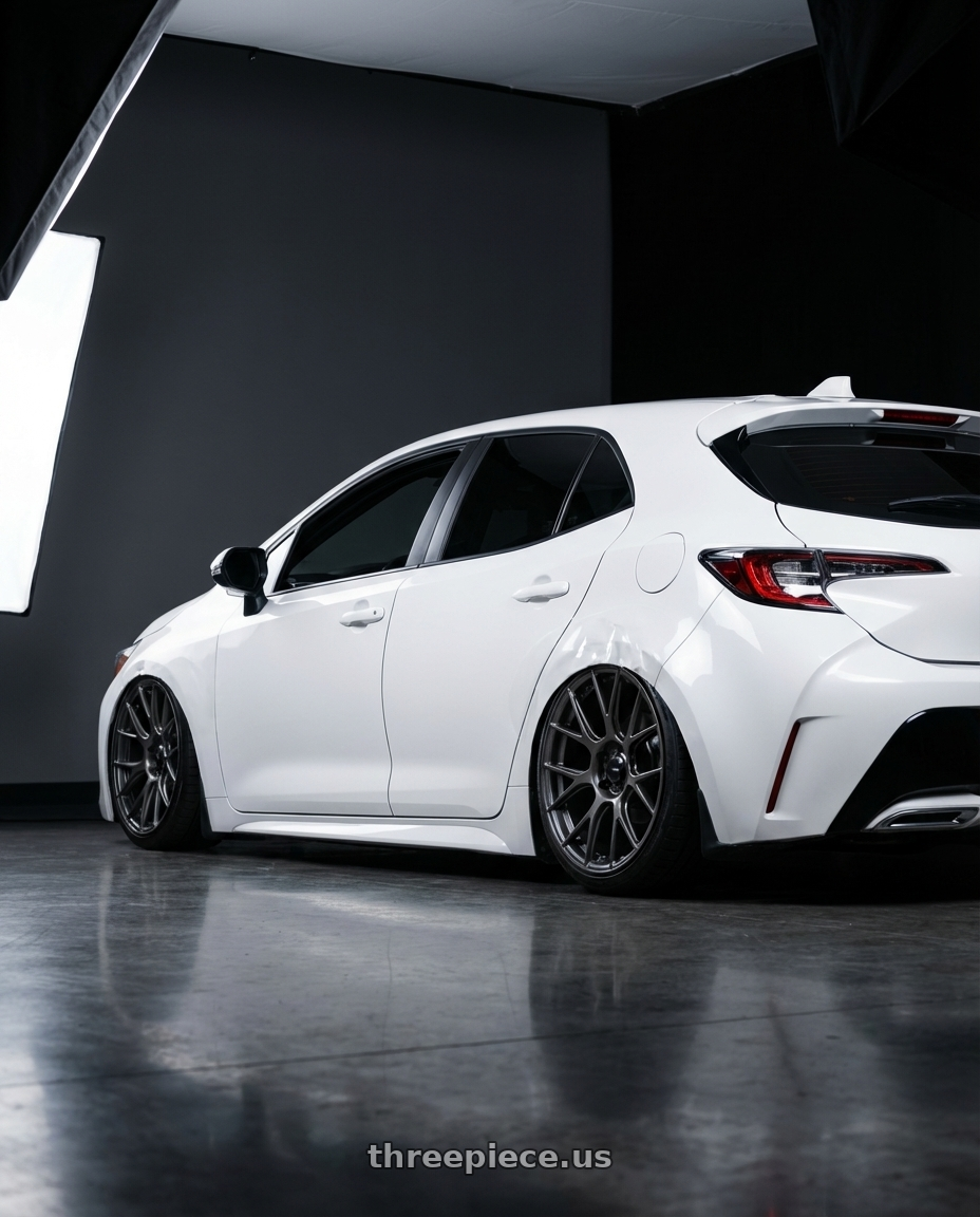 2023 Toyota Corolla Hatchback with Konig Ampliform 5x114.3 18x9.5+25 Dark Metallic Graphite wheels rear three quarter view slight stretch tires