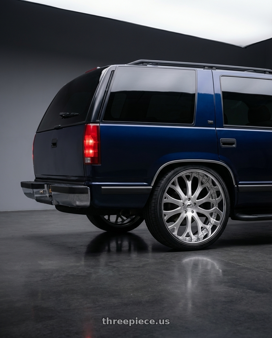 1999 Chevrolet Tahoe with Amani Tango 5x120/5x127 26x10 +5 Brush center Chrome lip wheels rear three quarter view square tires