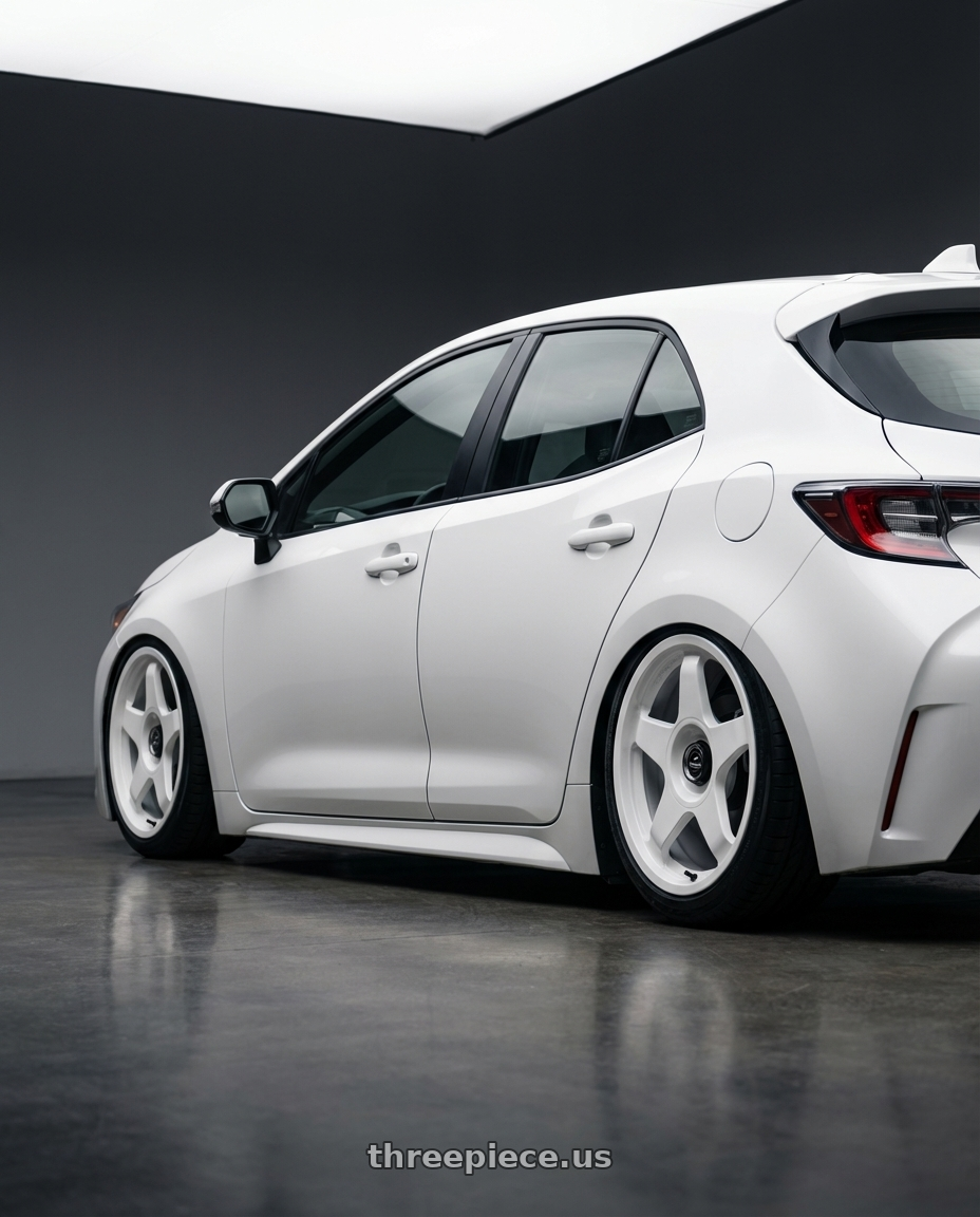2023 Toyota Corolla Hatchback with fifteen52 CHICANE 5x114.3 / 5x100 18x8.5 +35 RALLY WHITE (GLOSS WHITE) wheels rear three quarter view slight stretch tires