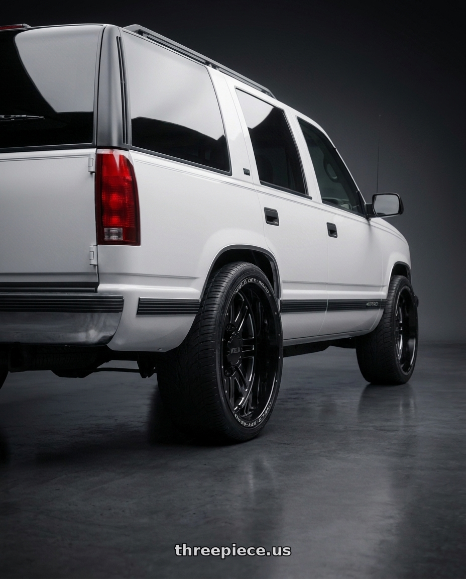 1999 Chevy Tahoe with WELD Off-Road Chasm 5x127 20x9 0 Gloss Black/Milled wheels rear three quarter view extreme stretch tires