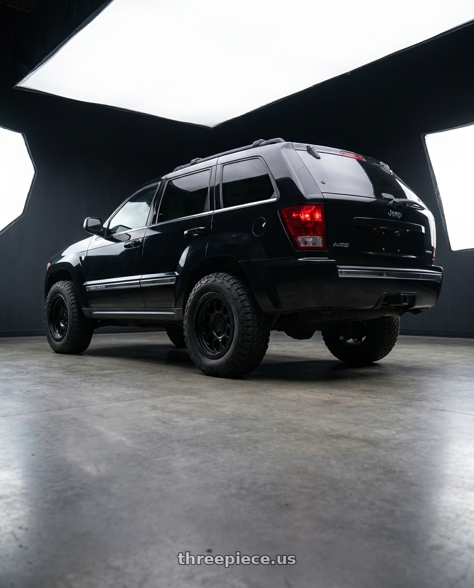 2006 Jeep Grand Cherokee with LOCK OFFROAD 50CAL 5x127 17x9 -12 Matte Black W Matte Black Ring wheels rear three quarter view meaty tires