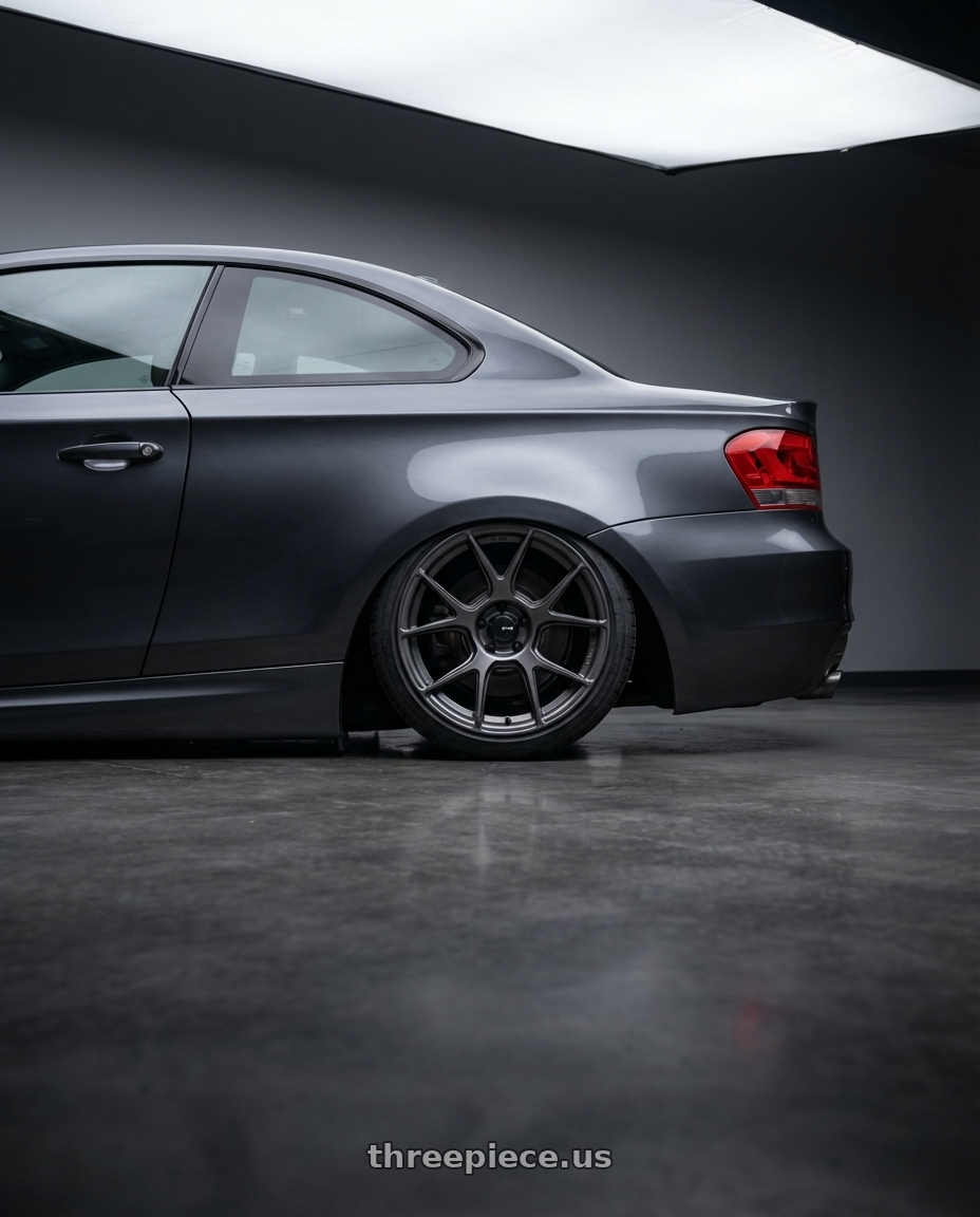 2012 BMW 1 Series E82 with Konig Ampliform 5x120 19x8.5+32 Dark Metallic Graphite wheels rear three quarter view slight stretch tires