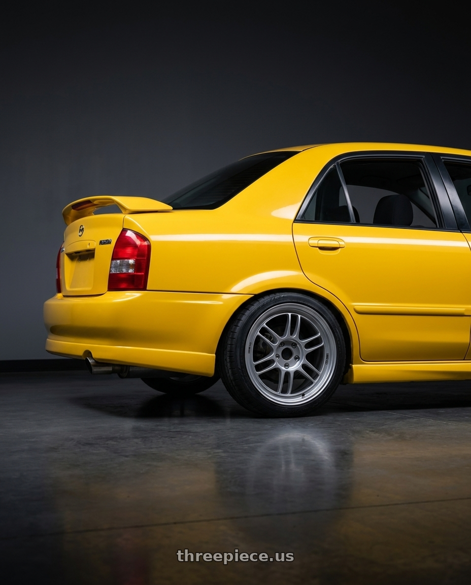 2003 Mazda Protege Mazdaspeed yellow with Enkei RPF1 5x114.3 17x7.5+48 Silver wheels rear three quarter view square tires