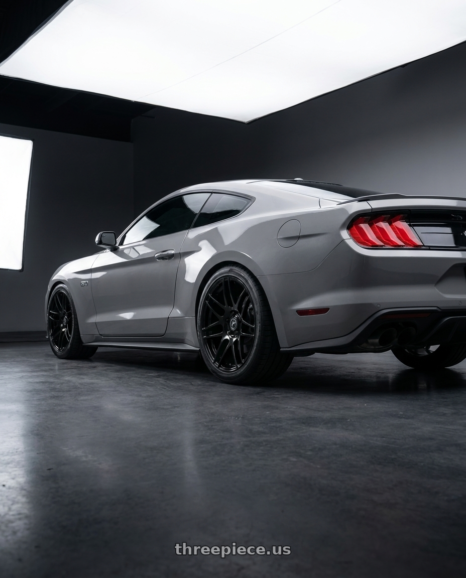 2021 Ford Mustang GT with Forgestar F14 5x114.3 18x9.5 +35 Gloss Black wheels rear three quarter view square tires