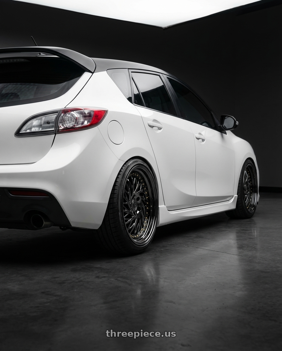 2012 Mazda Mazdaspeed3 with Aodhan DS03 5x114.3 18x9.5 +30 Black Vacuum w/ Gold Rivets wheels rear three quarter view square tires