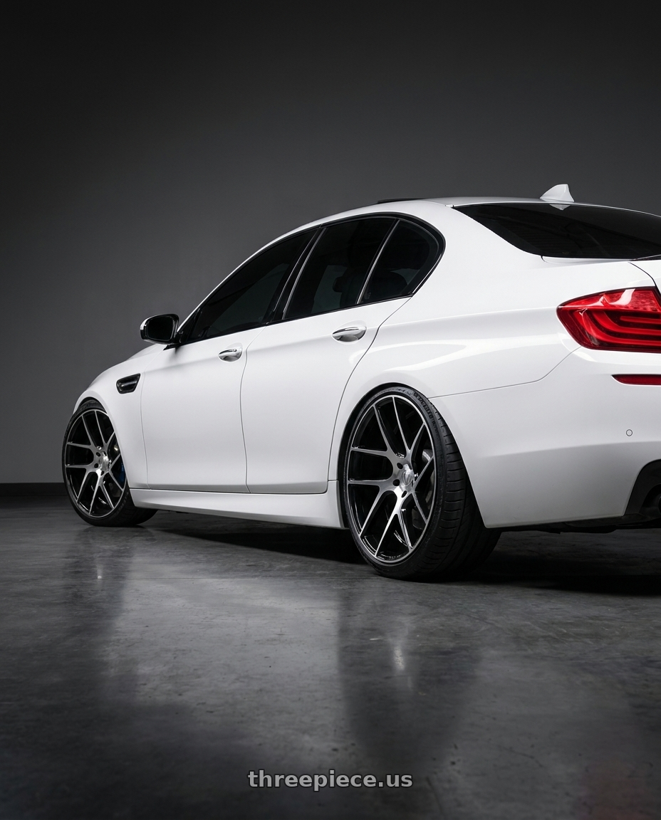 2012 BMW 550i with Status JUGGERNAUT 5X139.7 20X9 +20 GLOSS BLACK W/ MACHINED FACE wheels rear three quarter view extreme stretch tires