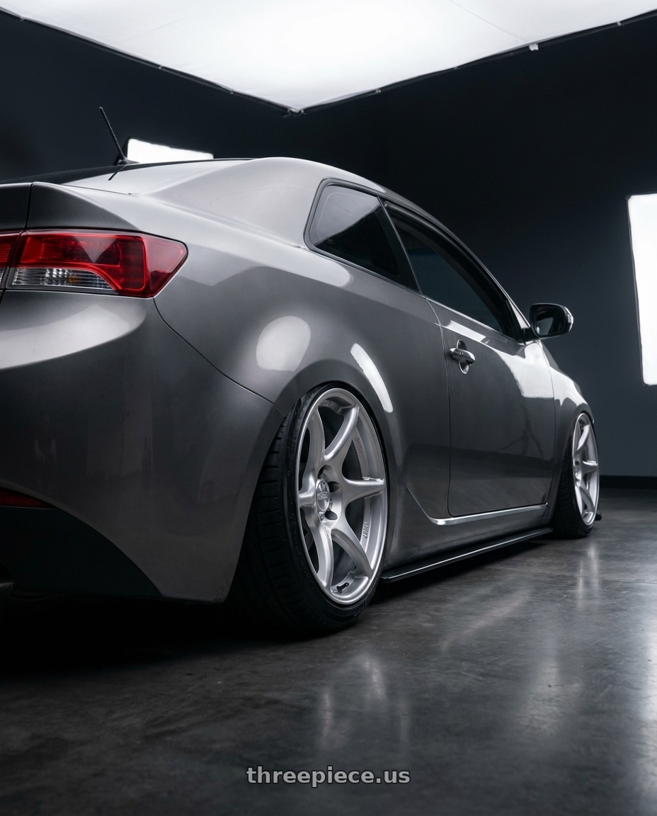 2011 Kia Forte Koup SX (Titanium Paint color) with Kansei K11S Tandem 5x114.3 18x8.5 35 Hyper Silver wheels rear three quarter view slight stretch tires