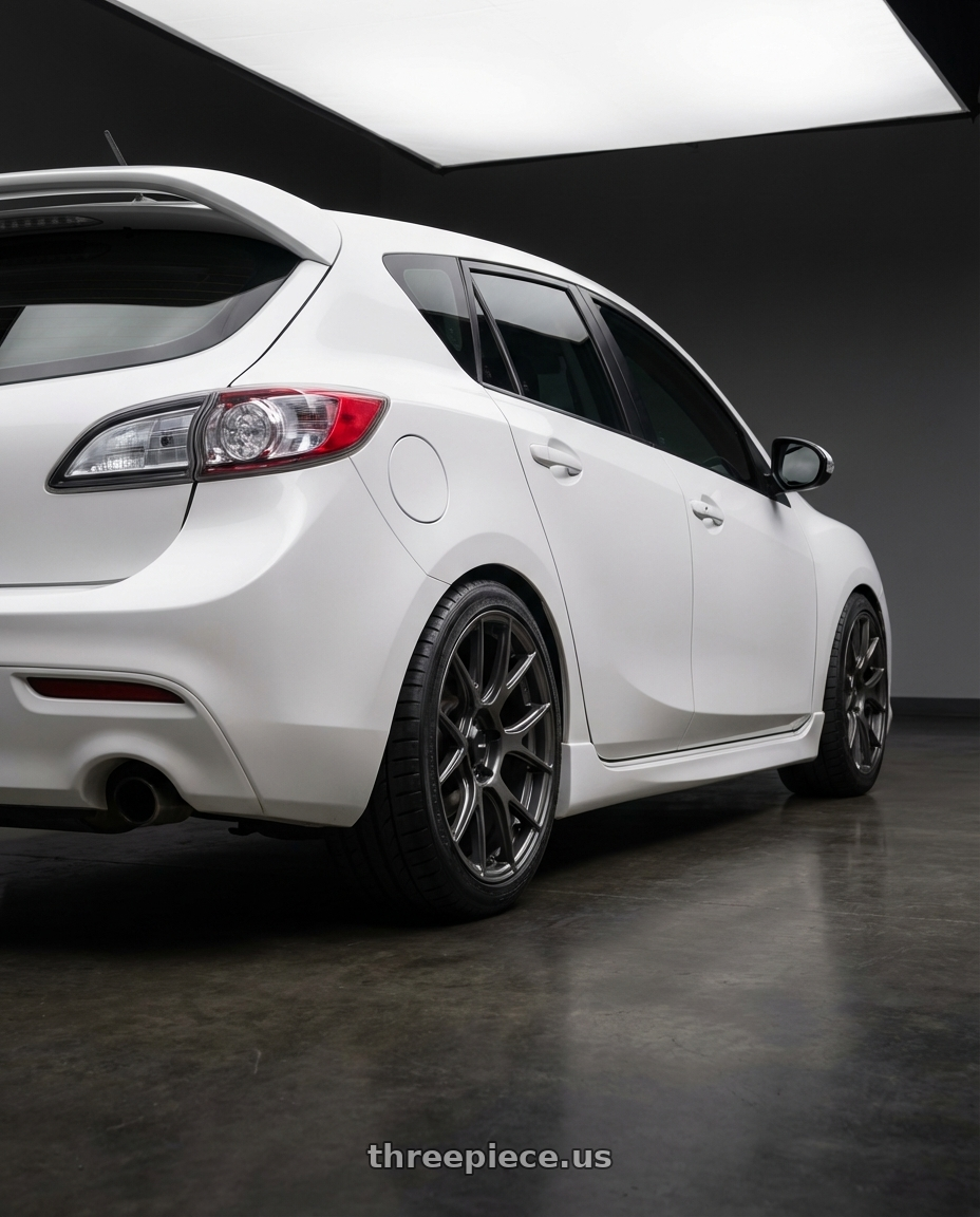 2012 Mazda Mazdaspeed3 with Konig Ampliform 5x114.3 18x9.5+35 Dark Metallic Graphite wheels rear three quarter view square tires