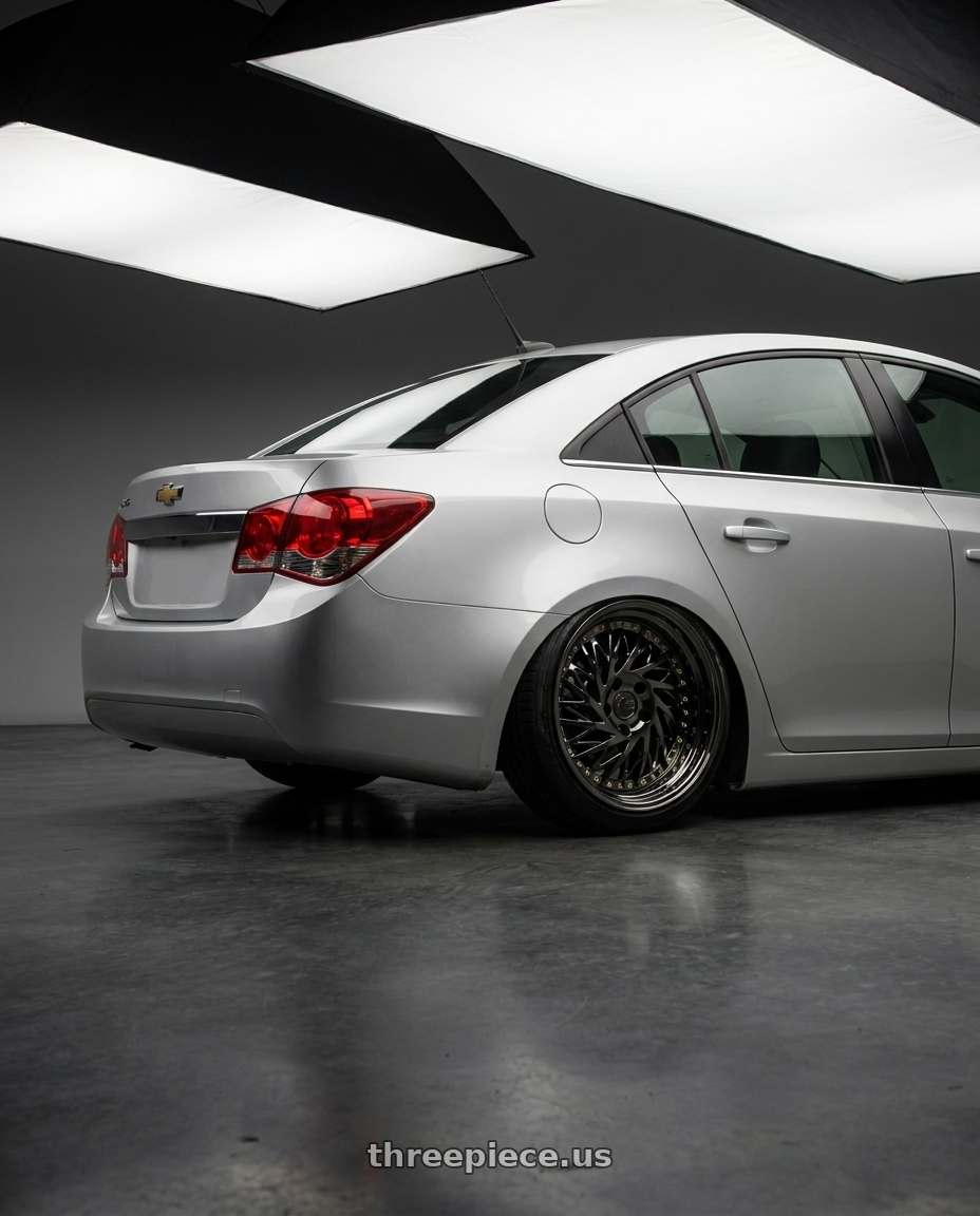 2015 Chevy cruze with Aodhan DS03 5x100 18x9.5 +35 Black Vacuum w/ Gold Rivets wheels rear three quarter view slight stretch tires