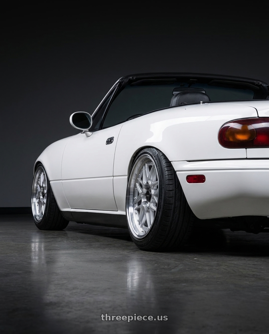 1990 Mazda Miata base model with Vors VR7 4x100/4x114.3 15x7  +35 Silver Machine Face Lip Chrome Rivet wheels rear three quarter view slight stretch tires