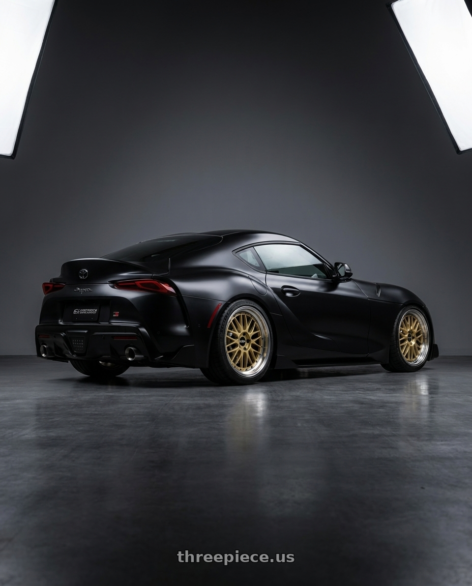  2022 Supra A90 with BBS LM 5x114.3 18x9.0+42 Gold wheels rear three quarter view square tires