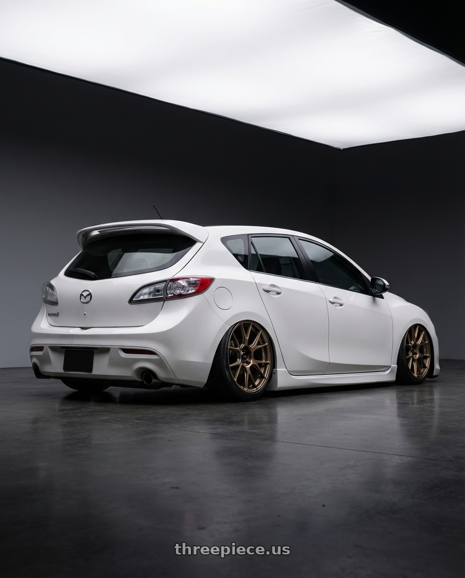 2012 Mazda Mazdaspeed3 with Konig Ampliform 5x114.3 18x9.5+25 Gloss Bronze wheels rear three quarter view slight stretch tires