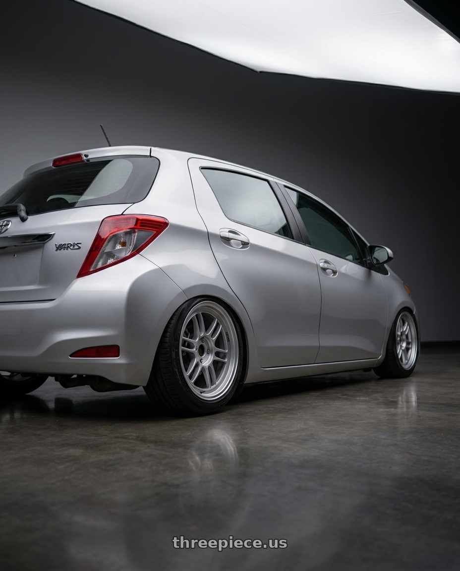 2015 Toyota yaris with Enkei RPF1 4x100 16x7+43 Silver wheels rear three quarter view slight stretch tires