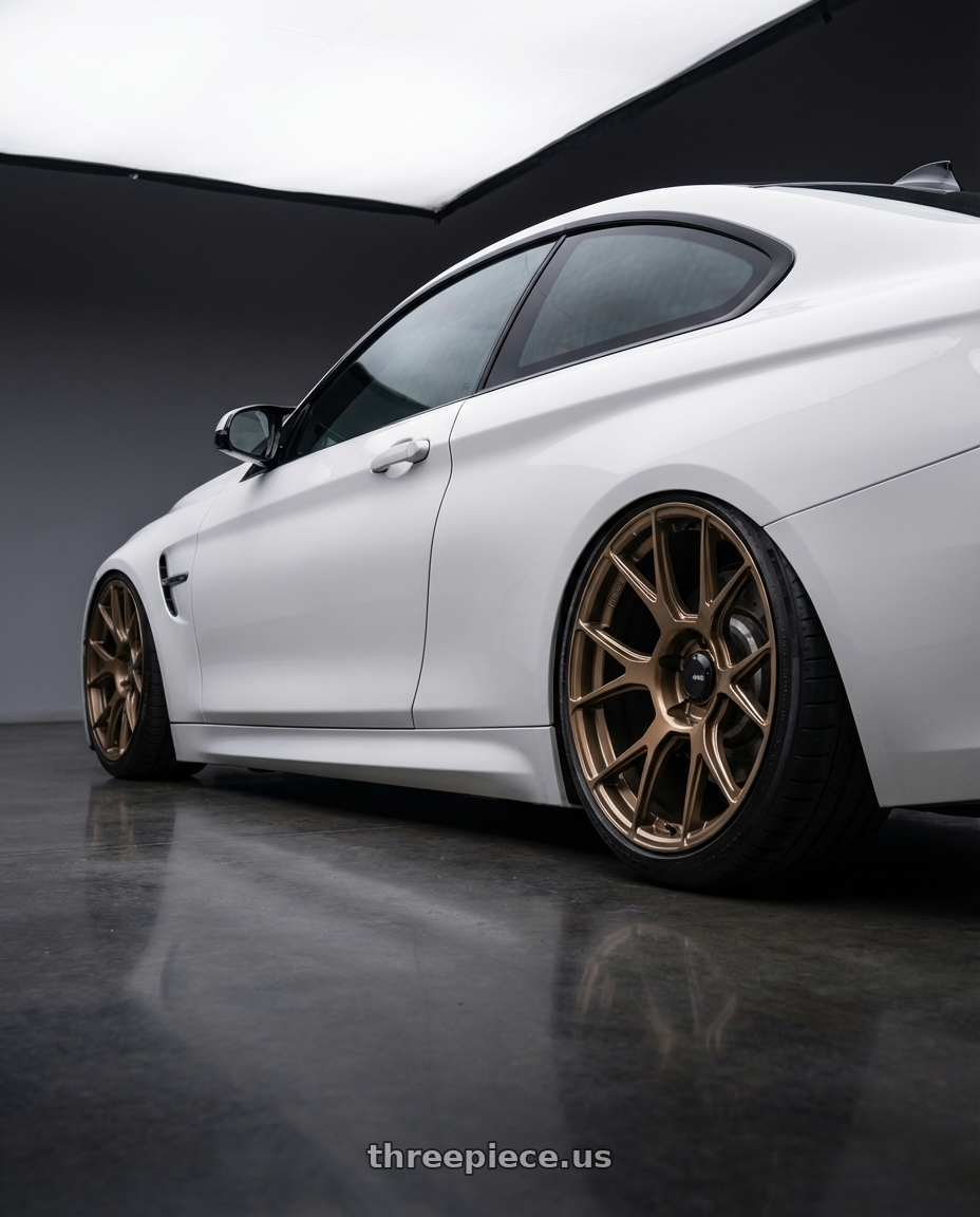 2018 BMW M4 F82 with Konig Ampliform 5x120 19x10+28 Gloss Bronze wheels rear three quarter view slight stretch tires