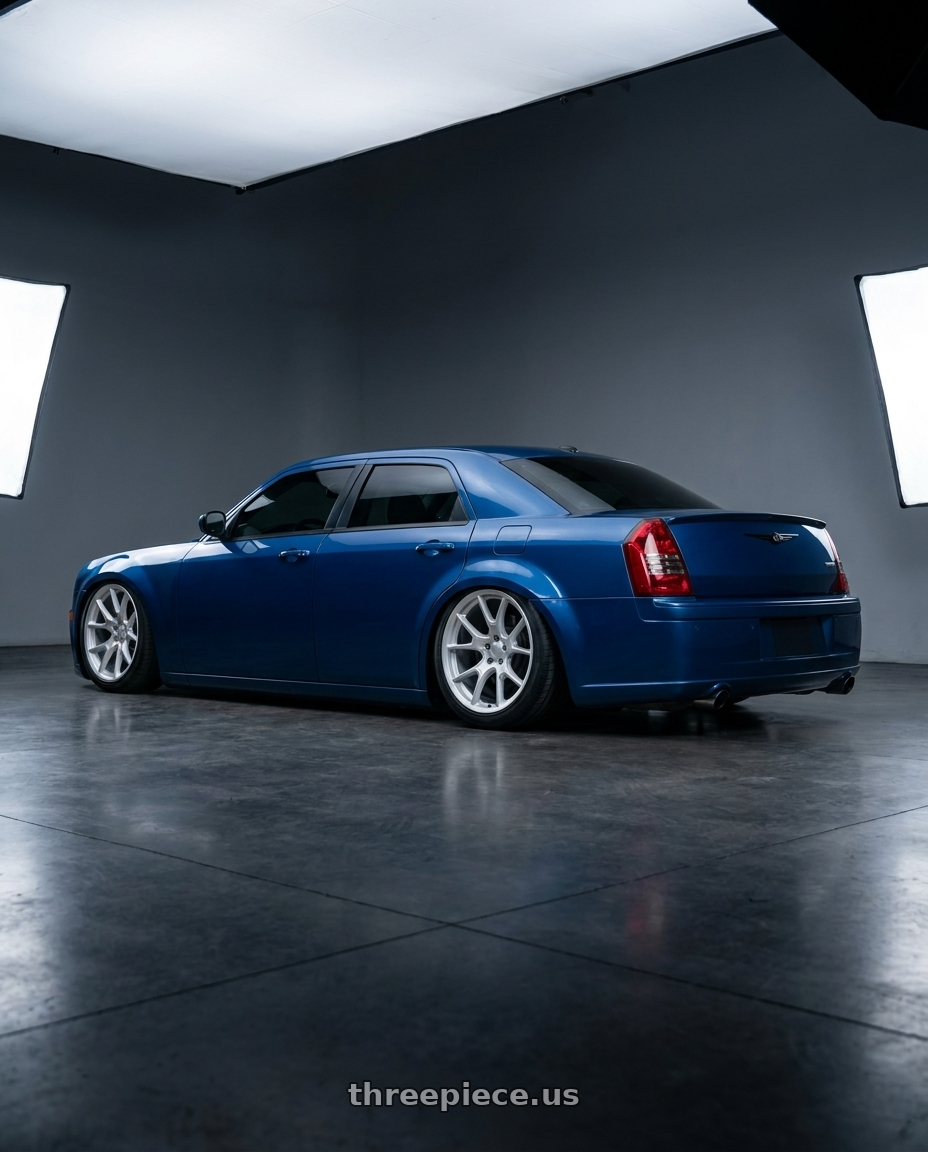 2007 Chrysler 300 srt8 blue with blacked out trim and grill and hellcat hood with Voxx Replica 50ANN 5x115 20x10.5+25 Matte Silver wheels rear three quarter view meaty tires