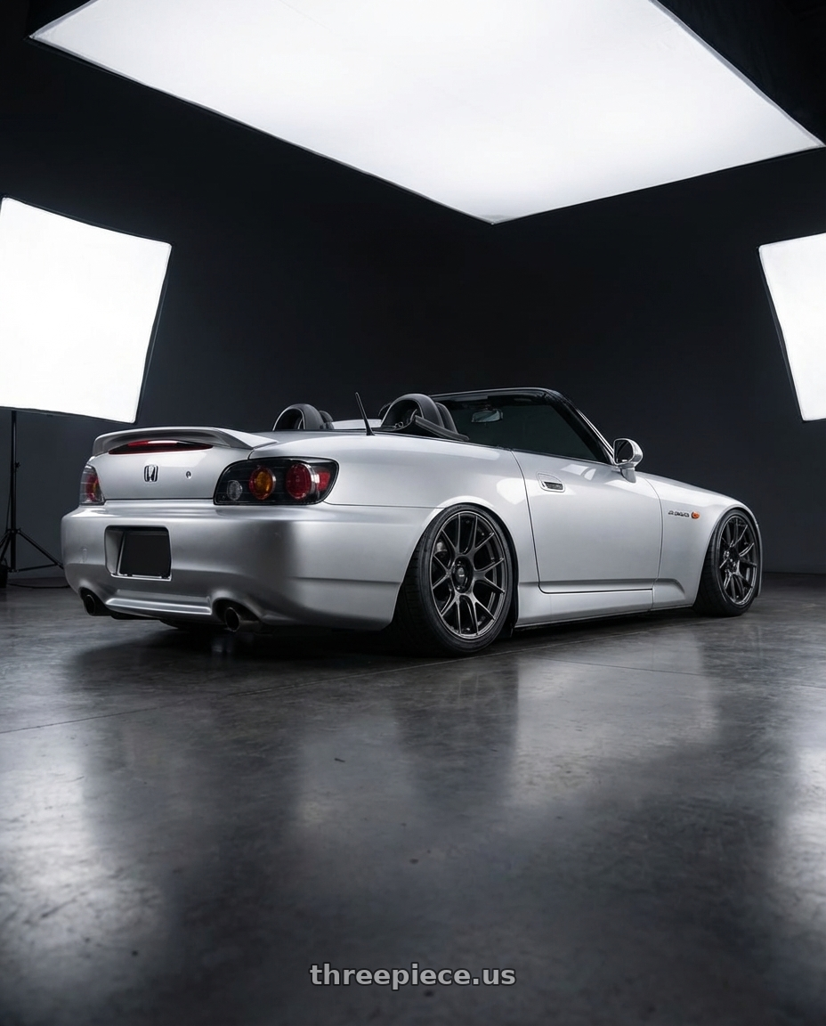 2009 Honda S2000 with Konig Ampliform 5x114.3 18x10+20 Dark Metallic Graphite wheels rear three quarter view slight stretch tires