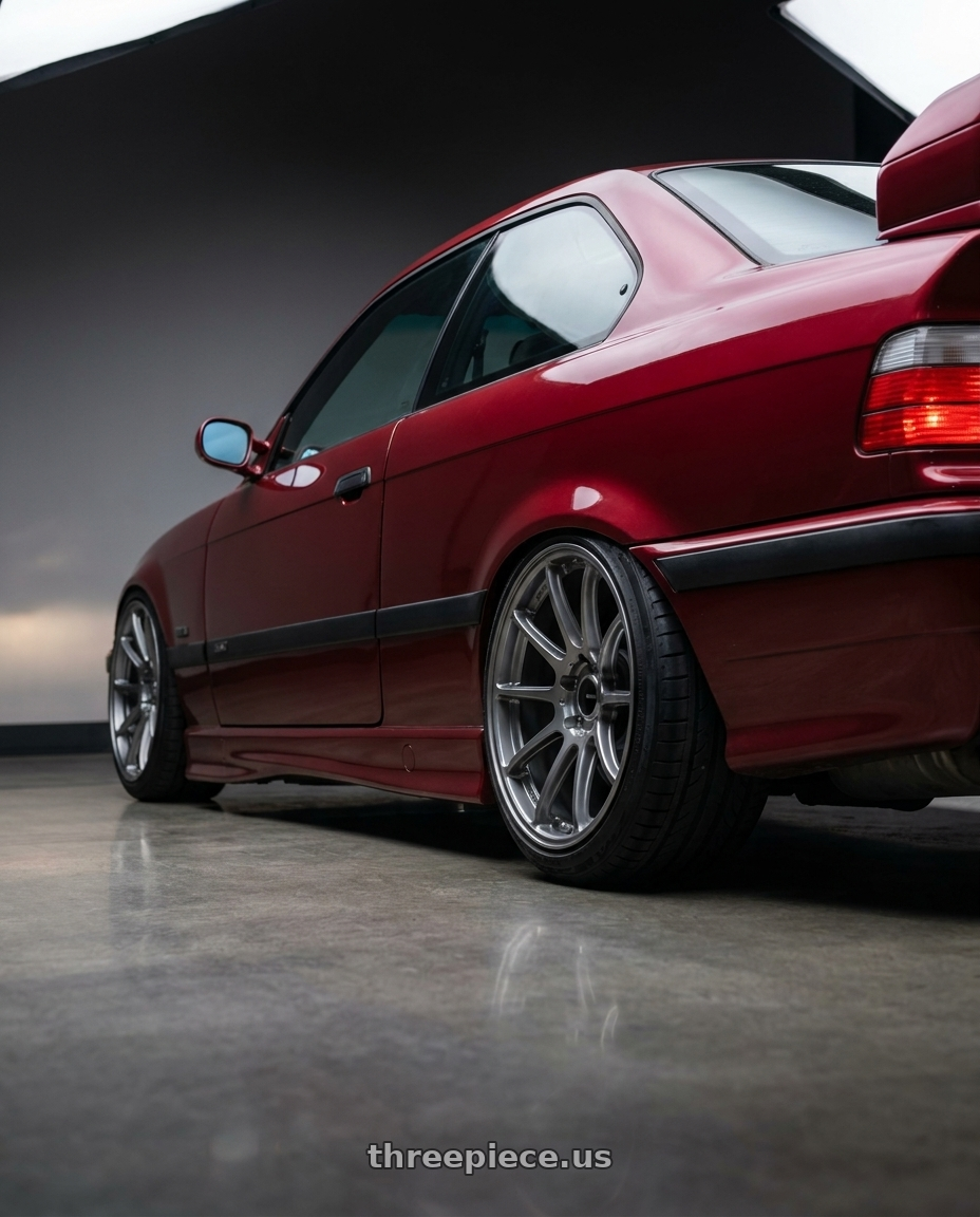 1996 BMW E36 328is with Enkei Triumph 5x114.3 18x8.5+38 Storm Gray wheels rear three quarter view slight stretch tires