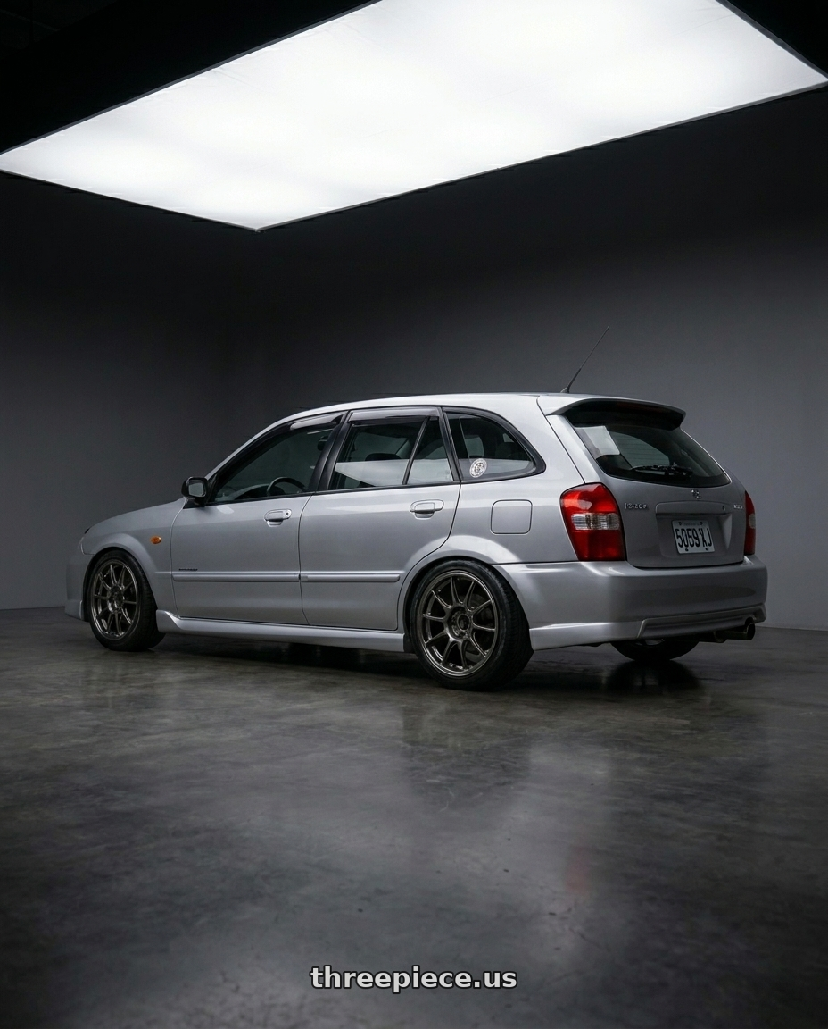 Mazda 323 2000 with WedsSport TC105X 4x100 15x8.0+35 EJ Titan wheels rear three quarter view extreme stretch tires
