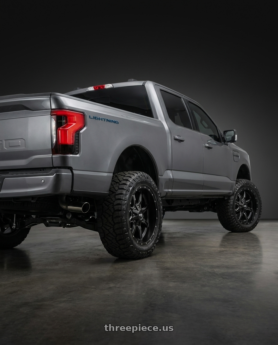2022 Ford F150 lightning with Moto Metal 970 5x127/5x139.7 20x10 -24 SEMI GLOSS BLACK MILLED wheels rear three quarter view square tires