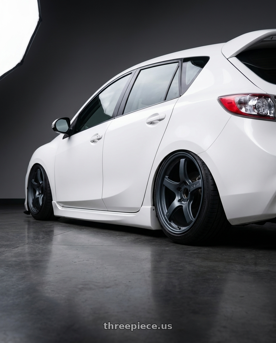 2012 Mazda Mazdaspeed3 with Gram Lights 57CR 5x114.3 18x9.5+38 Gunblue II wheels rear three quarter view slight stretch tires