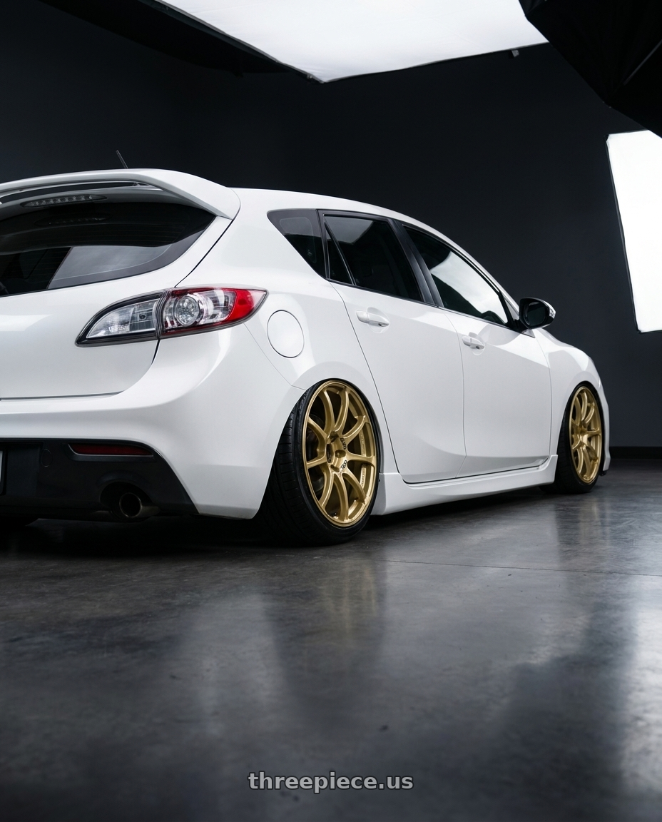 2012 Mazda Mazdaspeed3 with Advan RCIII 5x114.3 18x8.5+38 Gold wheels rear three quarter view slight stretch tires