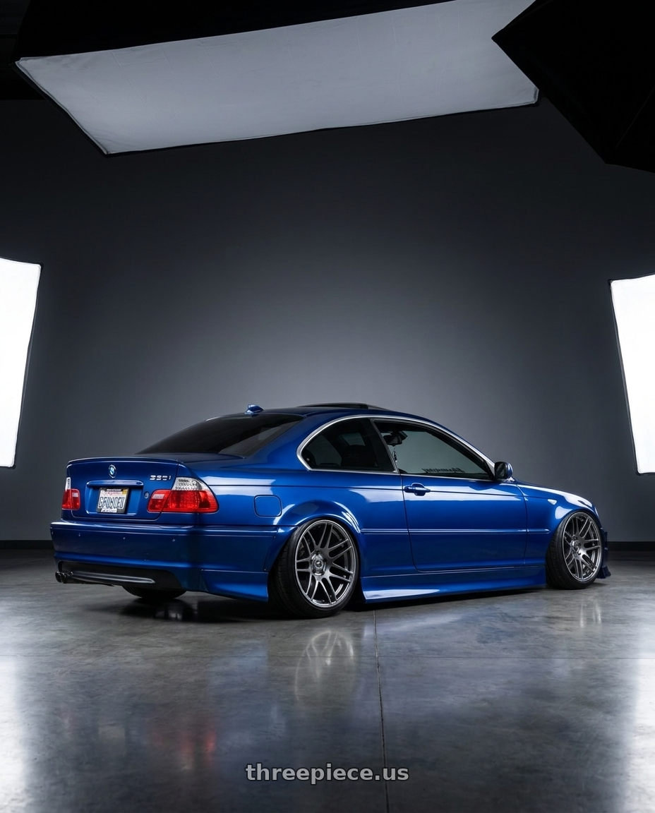 2005 BMW 330i with Forgestar F14 5x114.3 18x10 +42 Gloss Anthracite wheels rear three quarter view slight stretch tires