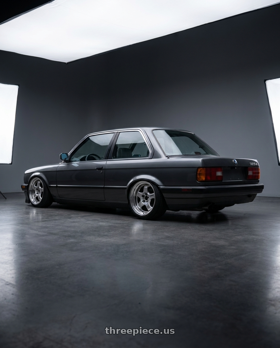 1986 BMW 325e with Work Meister S1 2P 4x100 15x6.5+22 O Disk Silver wheels rear three quarter view slight stretch tires